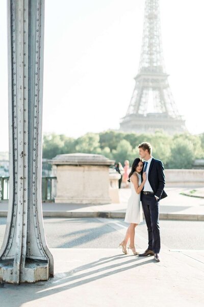 Un couple sous le pont de Bir-Hakeim, robe crème et costume marine.